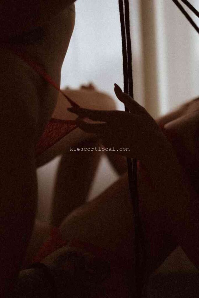 Silhouettes of two women in intimate embrace, suggestive of a threesome