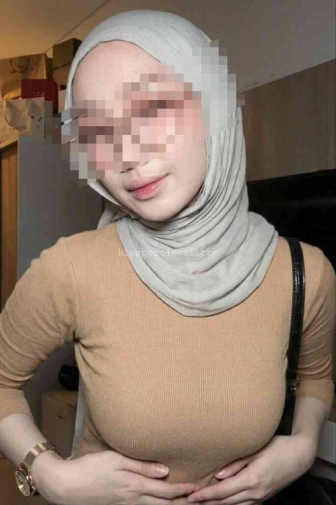 Woman in hijab and brown top with watch
